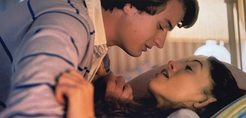 Stranger Things screenshot. Steve and Nancy make out on her bed.